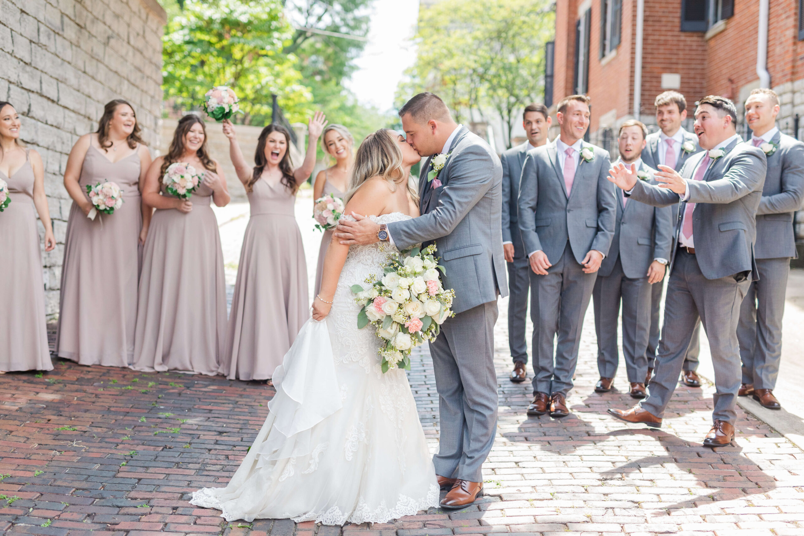 bride and groom kissing in front of bridal party