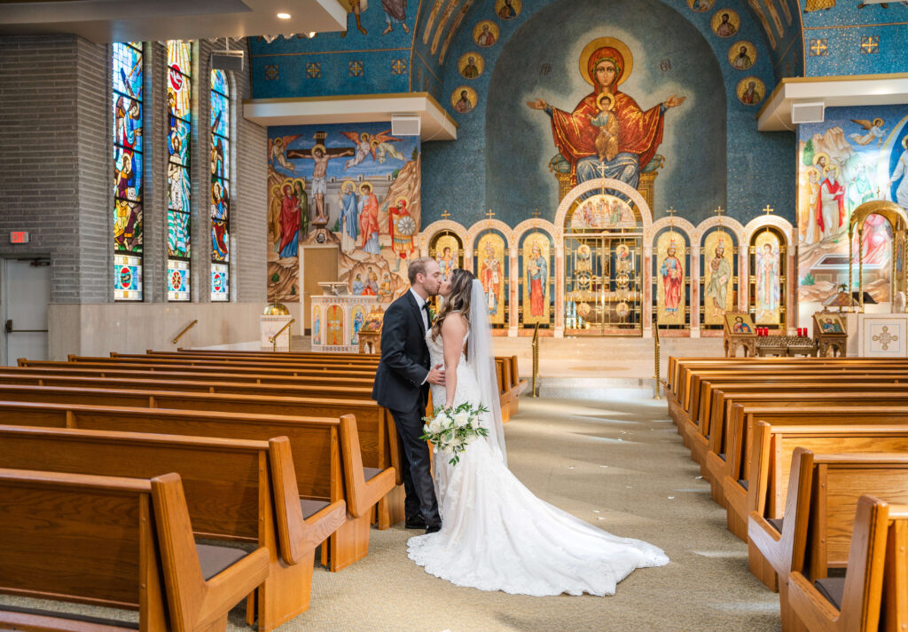 bride and groom kissing in st nicholas greek orthodox church