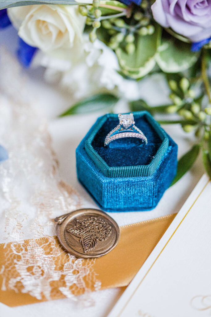 wedding ring in ring box next to wedding bouquet taken by cincinnati wedding photographer