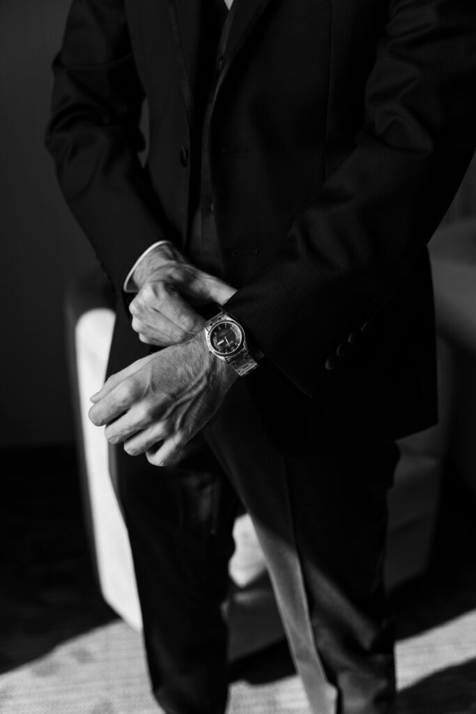 groom fitting his watch on his wedding day - black and white