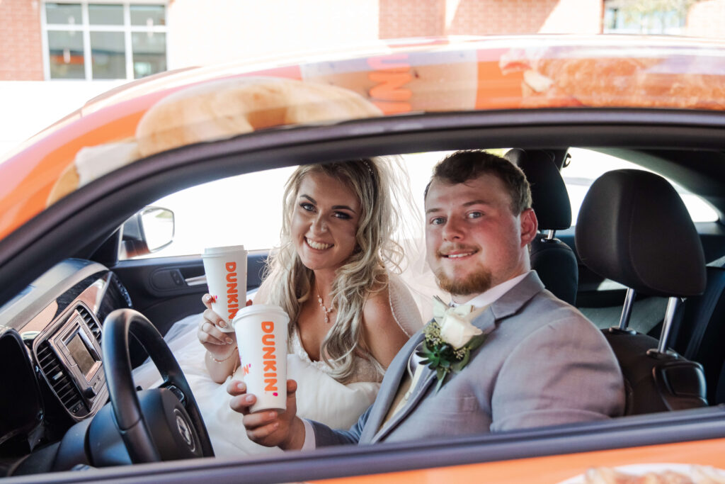 bride and groom going through a dunkin donuts drive through on their wedding day