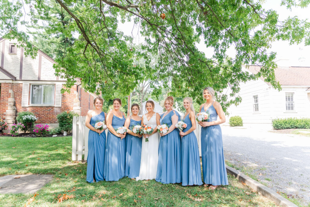bride on her wedding day and her bridesmaids outside of the barn in mariemont