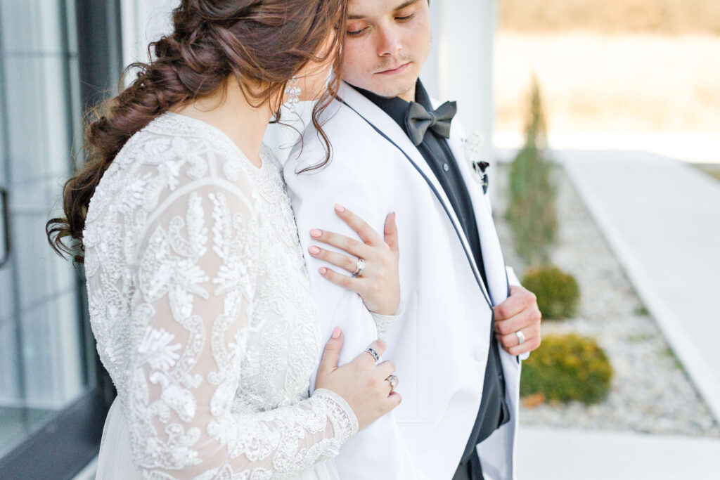 wedding photographer captures bride and groom outside as they're dressed in all white