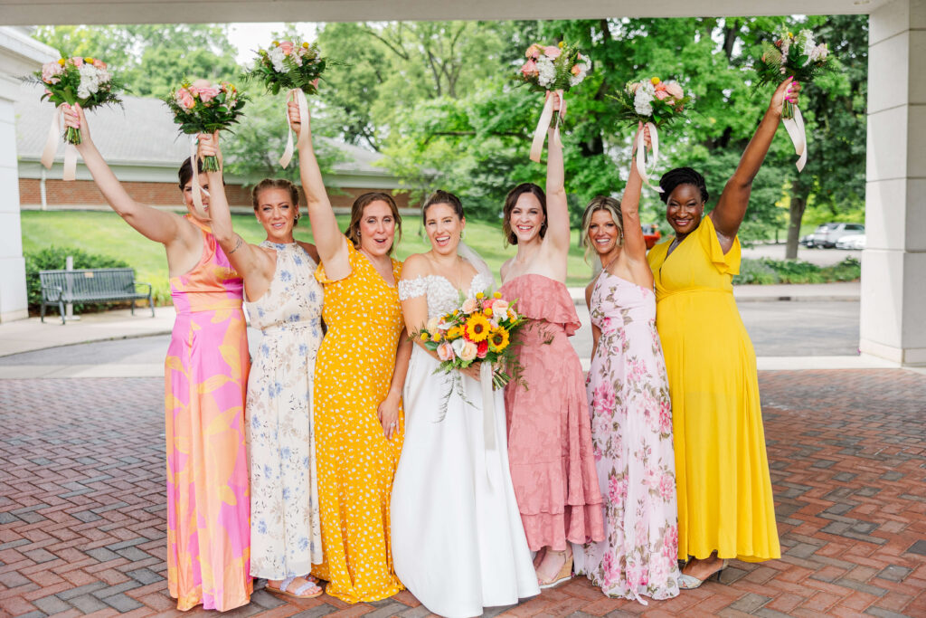 bridesmaids in colorful dresses standing in carillon park wedding