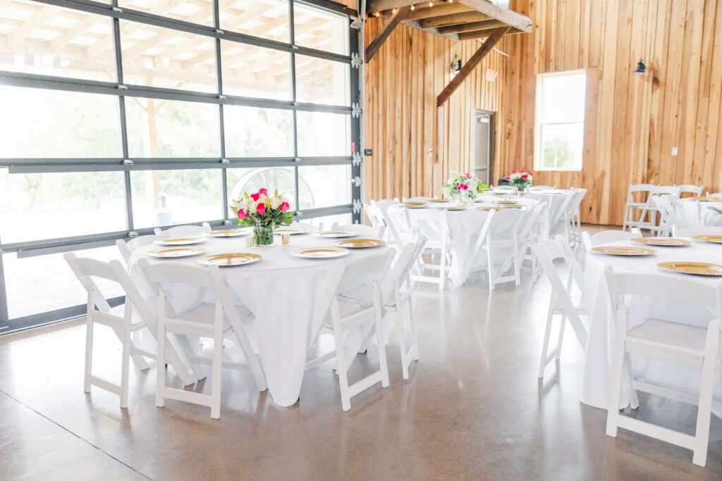 wedding reception setup with white tables at bryton barn venue