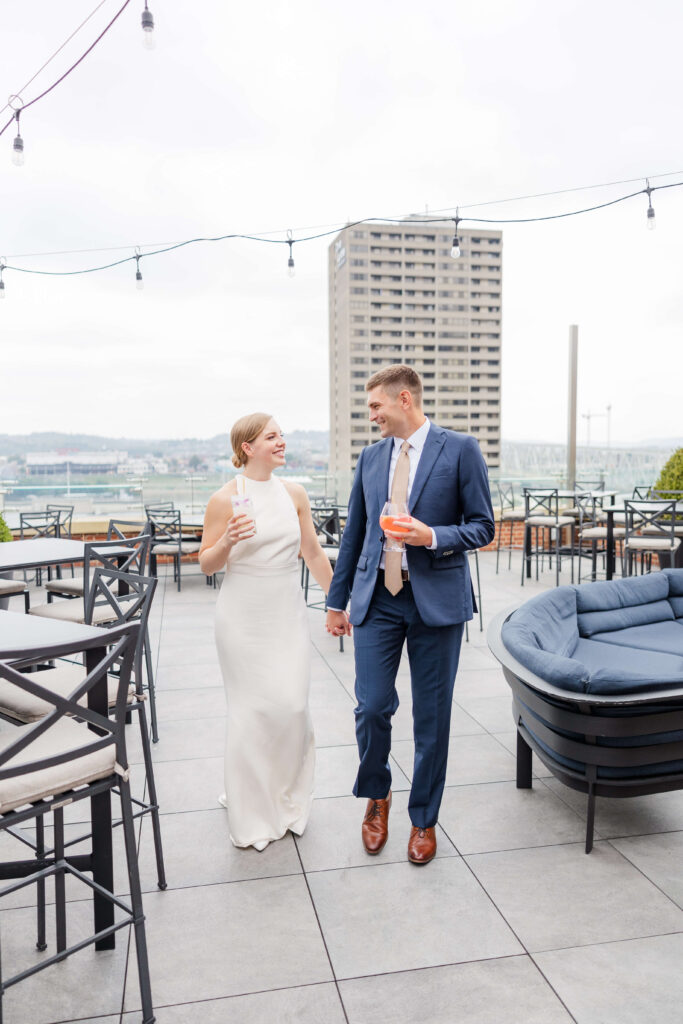 a bride and groom enjoy their drinks on the rooftop of the lytle park hotel wedding venue in downtown cincinnati